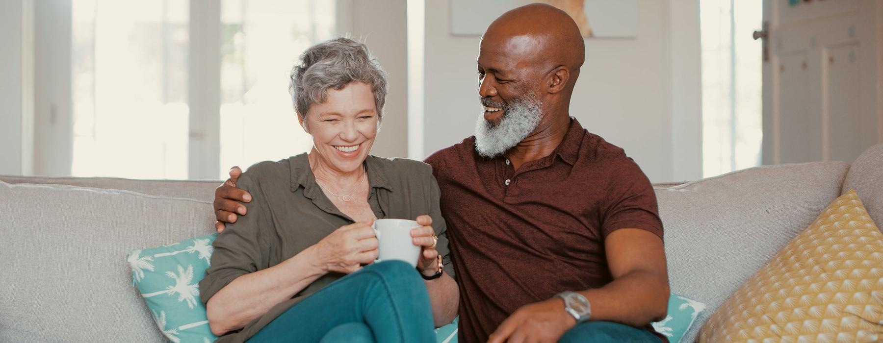 smiling, older couple, sit together on a couch
